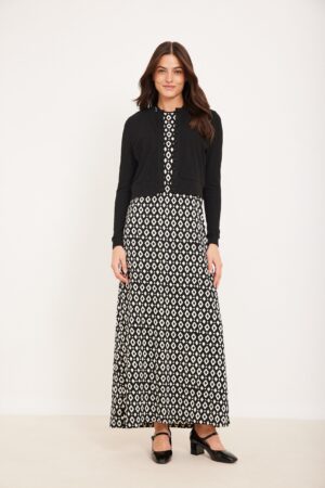 שמלת מקסי מנוקדת בשחור ולבן עם ז'קט אלגנטי רחב, מתאים לאופנה נוחה ומודרנית.