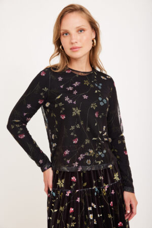 רושם צפוף של פרחים צבעוניים על חולצה ושני חלקי של טיקט ונעליים רכים לאירועים ולאירועים רשמיים.