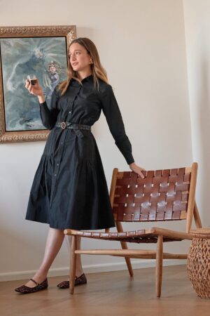 אשת אופנה בלבוש אופנתי, יפה ומרשים באווירת עיצוב וצבעים ליד יצירה אומנותית.