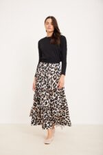 רושם של אופנה נוח ואלגנטית במגוון בלייזר שחור וחצאית בלבן עם הדפס מנומר.