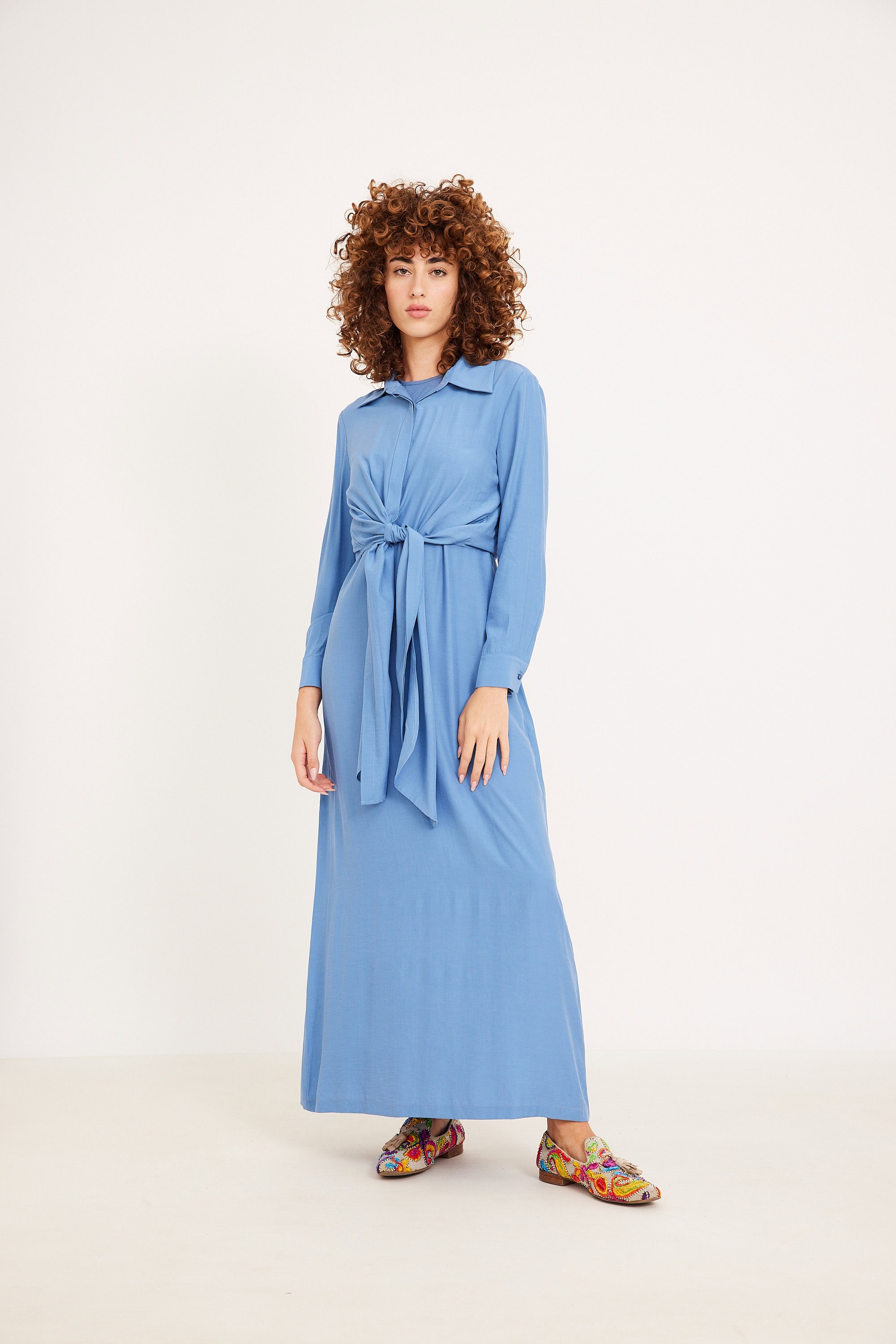 שמלה שחורה וחולצת קשירה שמנת בלוג אורך שמלה ארוכה בסגנון נוחות ואופנה, בשילוב עם נעלי צבעוניות אופנתיות.