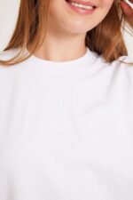 אלט טקסט: גבר לובש חולצה לבנה נוחה באופנת אורדמן, עם לוגו עדין על החזה.