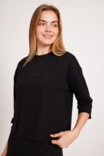 שחור עליונית אופנתית לנשים עם לוגו עדין וסטייל נוח ללבוש.